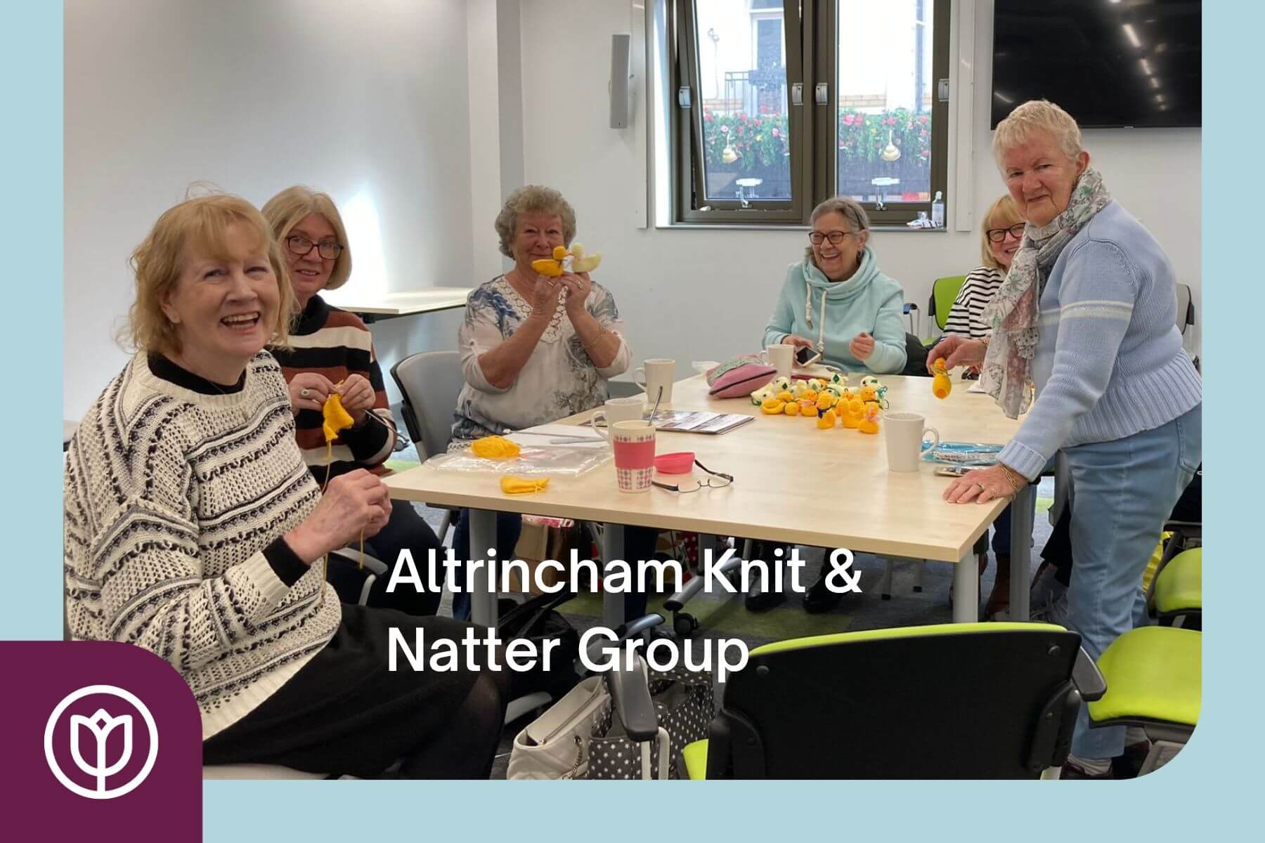 A group of older women smiling and knitting together at a table, with "Altrincham Knit & Natter Group" text overlay. - Home Instead