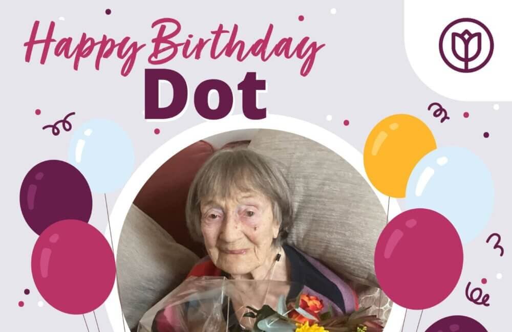 Elderly woman holding flowers, surrounded by balloons and "Happy Birthday Dot" text. - Home Instead