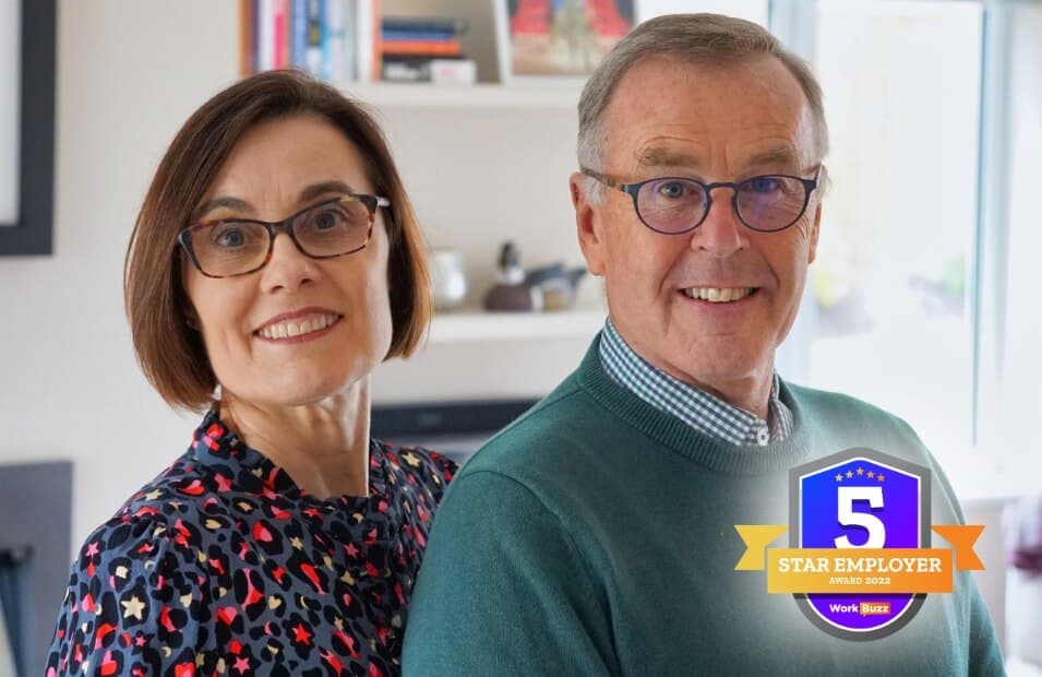 Two people wearing glasses are smiling. A "5 Star Employer" badge from WorkBuzz 2022 is at the bottom right. - Home Instead