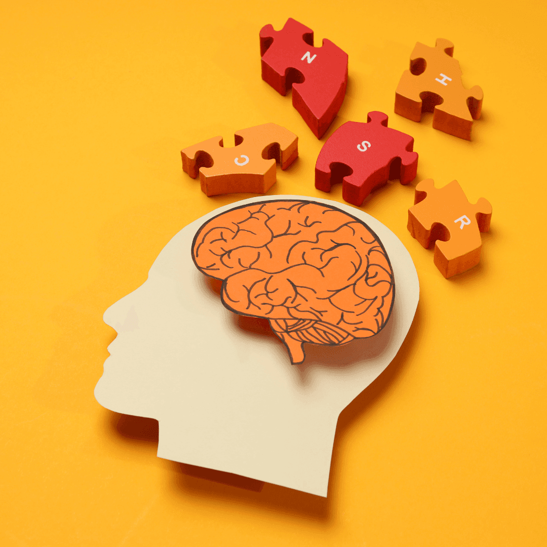 Illustration of a human head silhouette with a brain and scattered puzzle pieces on an orange background. - Home Instead