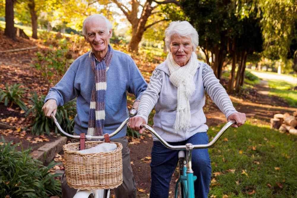 Senior couple riding their bike in a park