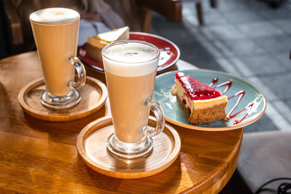 Classic New York Cheesecake And Coffee Latte on a table in cafe. Top view.
