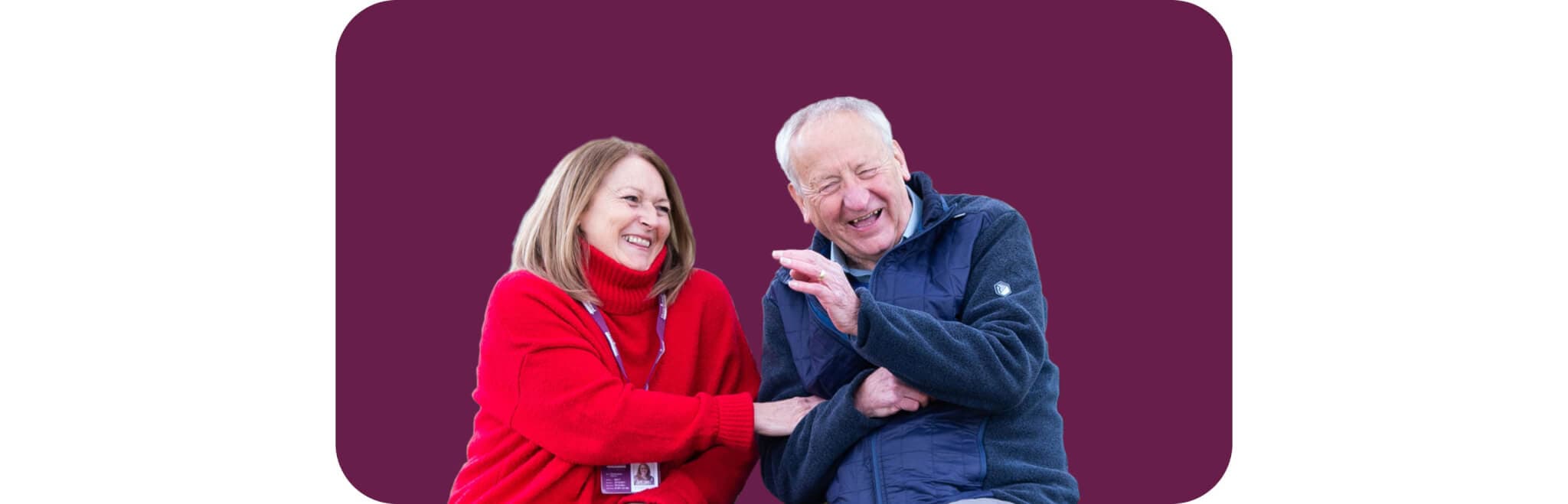 A woman in a red sweater and an elderly man in a dark jacket share a joyful moment laughing together. - Home Instead