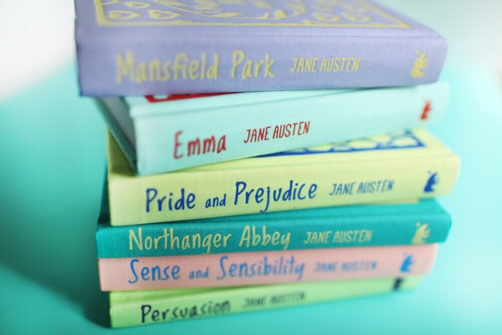 A stack of colorful Jane Austen books, including "Mansfield Park," "Emma," "Pride and Prejudice," and others. - Home Instead