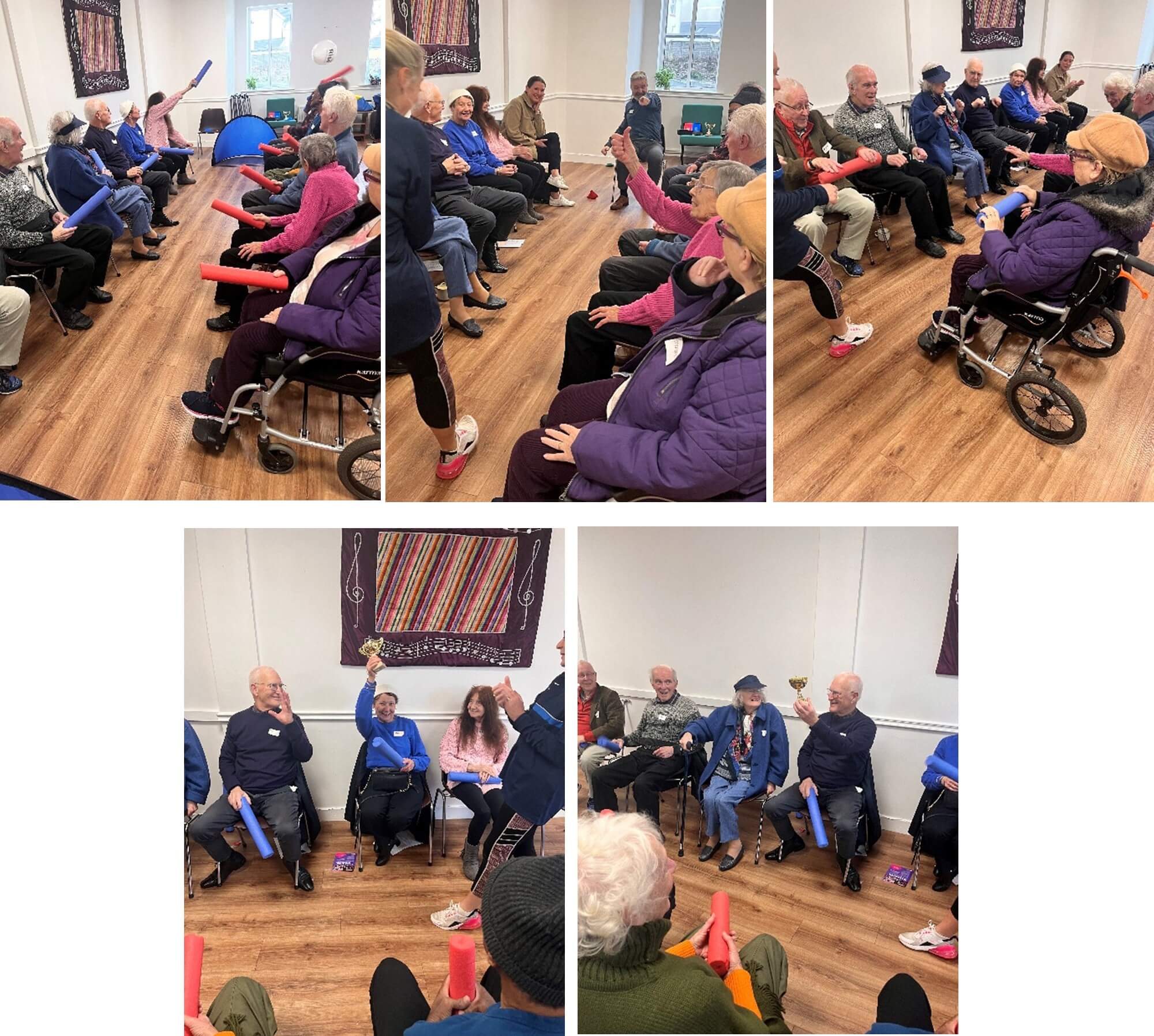 Elderly people in a community room seated in a circle participating in a group activity with colorful equipment. - Home Instead