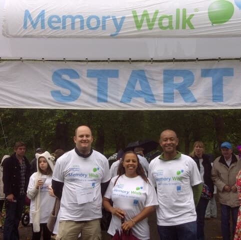Participants gather under the "Memory Walk" starting line banner, ready to begin the event. - Home Instead