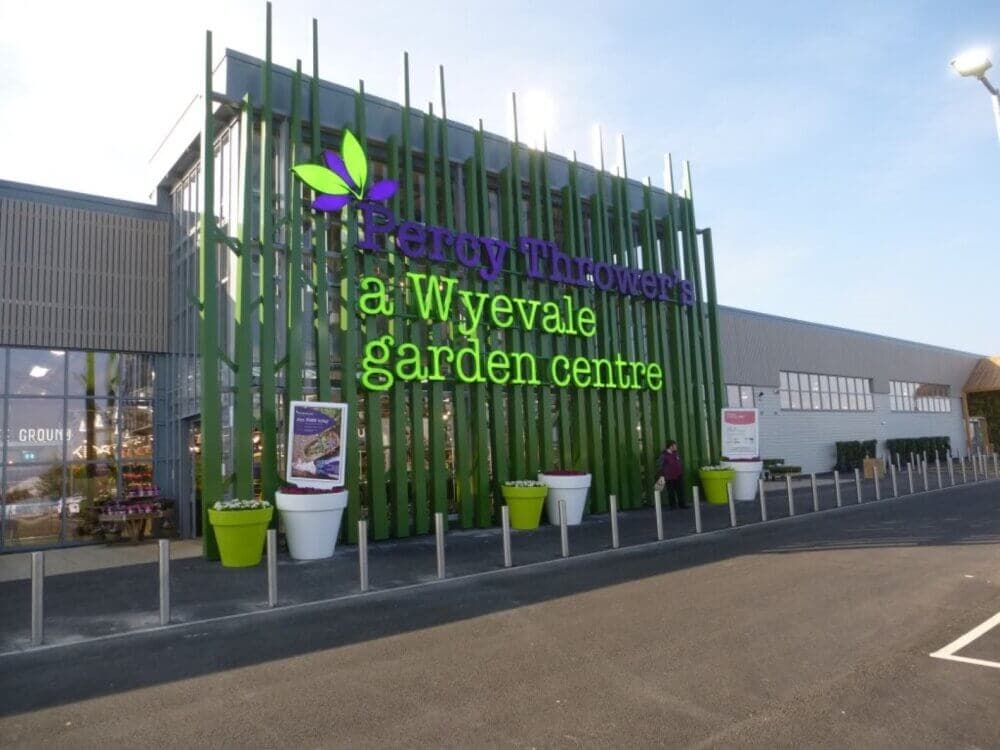 Front entrance to Percy Thrower's Wyevale Garden Centre with green accents and signage. - Home Instead