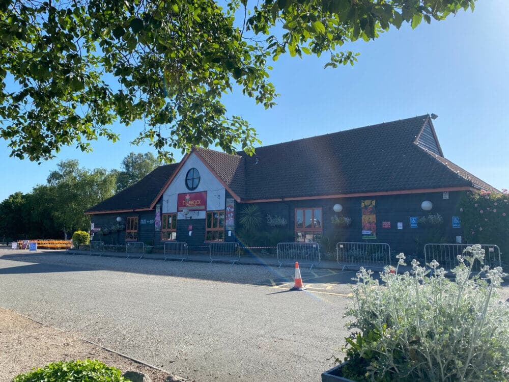 A building with a sign "Hard Rock" on its facade, surrounded by greenery, under a clear blue sky. - Home Instead