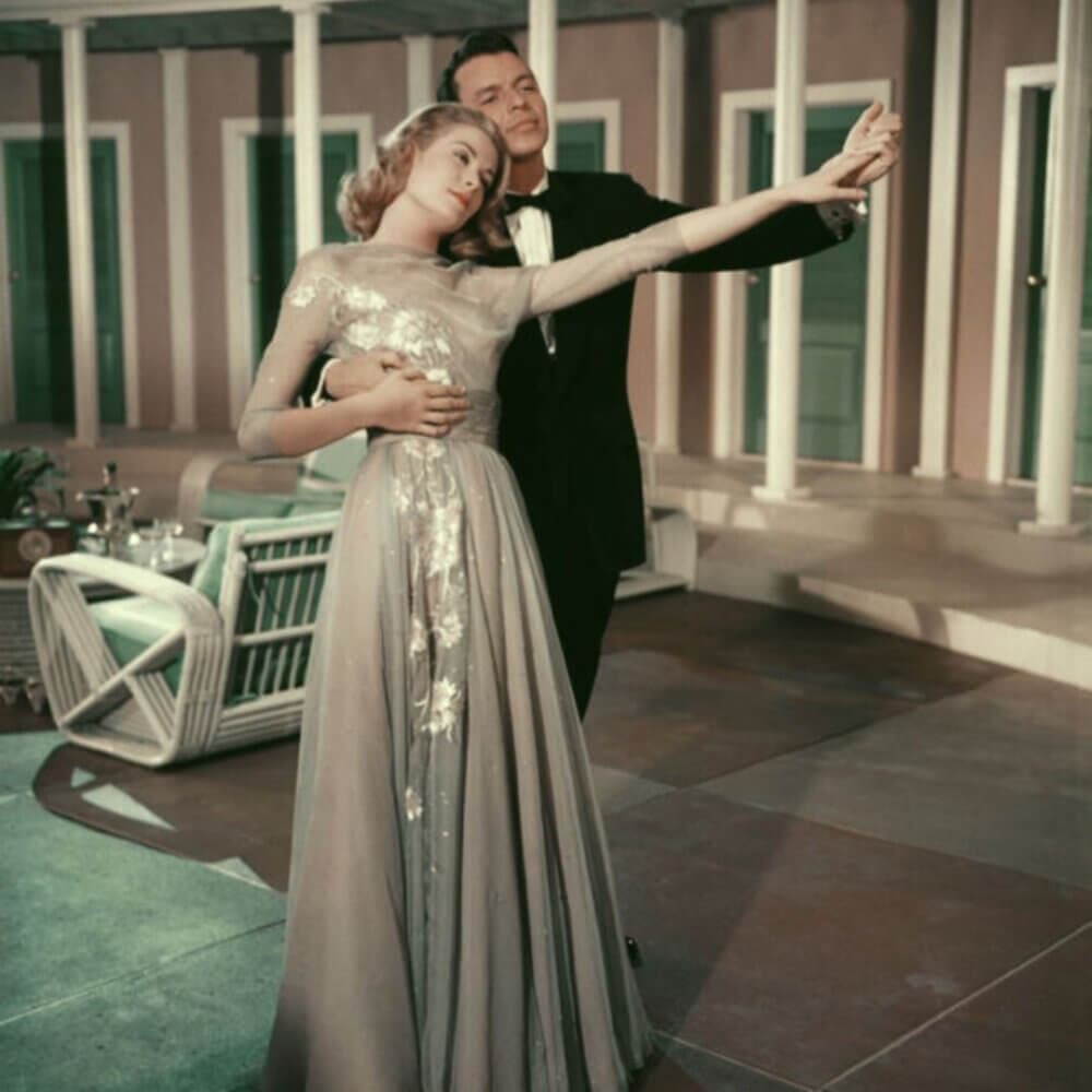 A couple in formal attire dance gracefully indoors, surrounded by elegant furnishings and pillars. - Home Instead