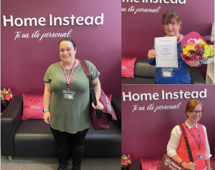 Three women at Home Instead office, one standing with a bag, one holding flowers and certificate, one with a sash and bag. - Home Instead