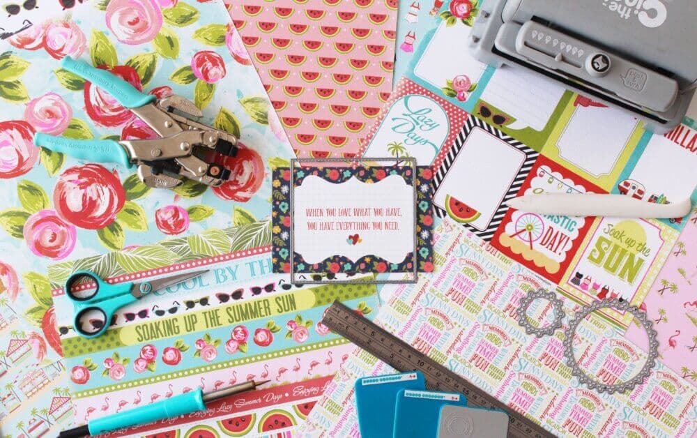 Colorful scrapbook supplies including patterned paper, scissors, stamps, a ruler, crafting tools, and a motivational card. - Home Instead