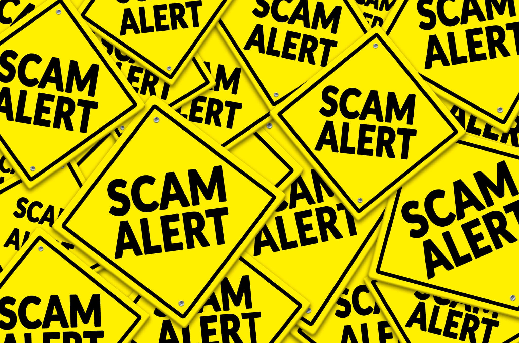 A pile of yellow road signs with the text "SCAM ALERT" written in bold black letters. - Home Instead