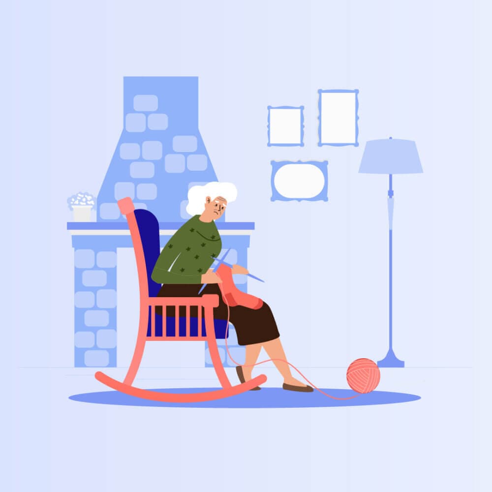 An elderly woman knitting in a rocking chair near a fireplace, with empty picture frames and a floor lamp in the background. - Home Instead