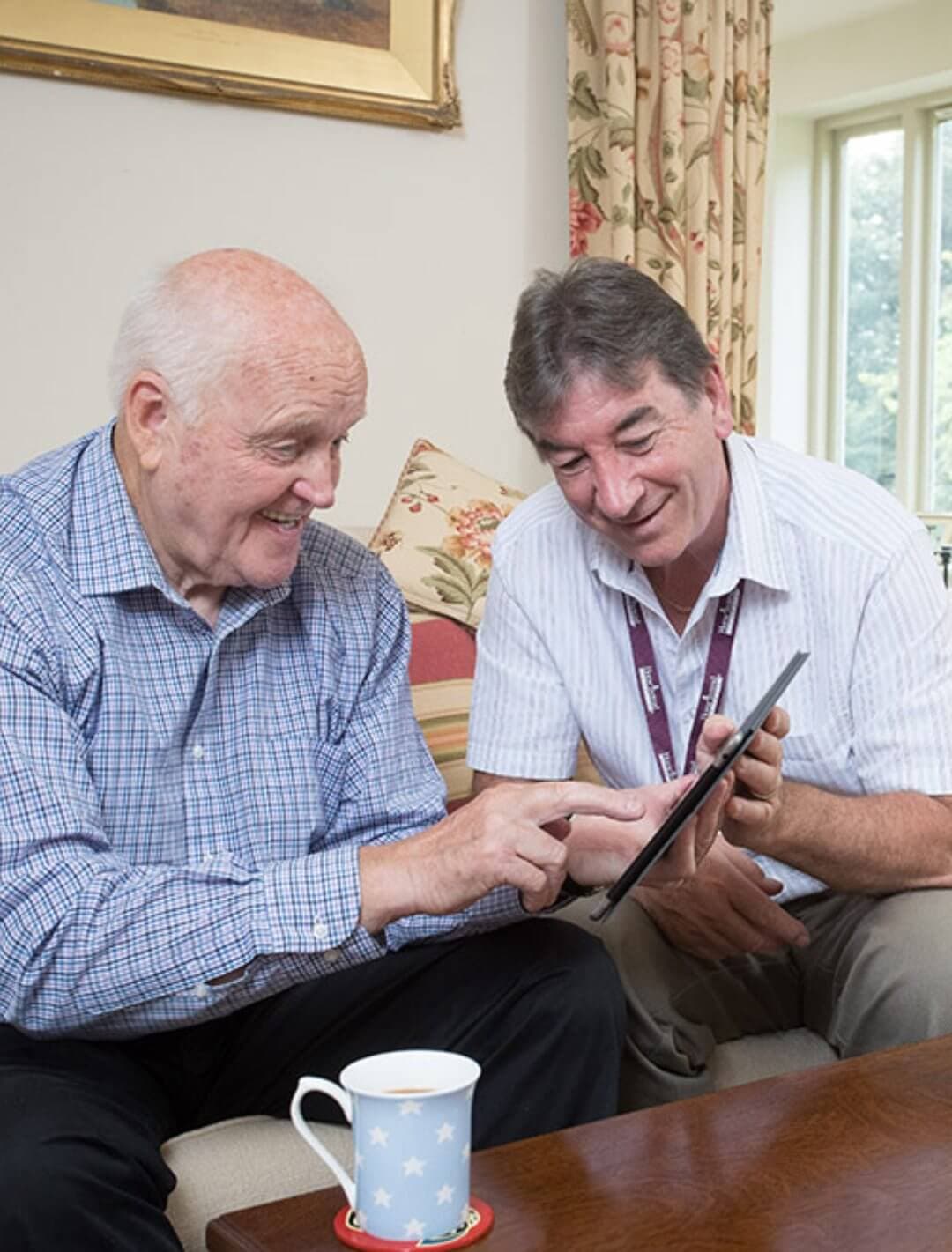 Home Instead Southampton Care Professional with client using tablet