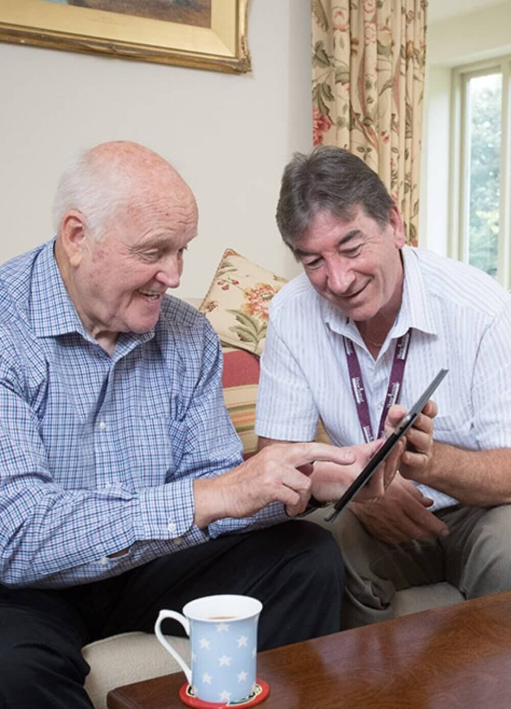 Home Instead Southampton Care Professional with client using tablet