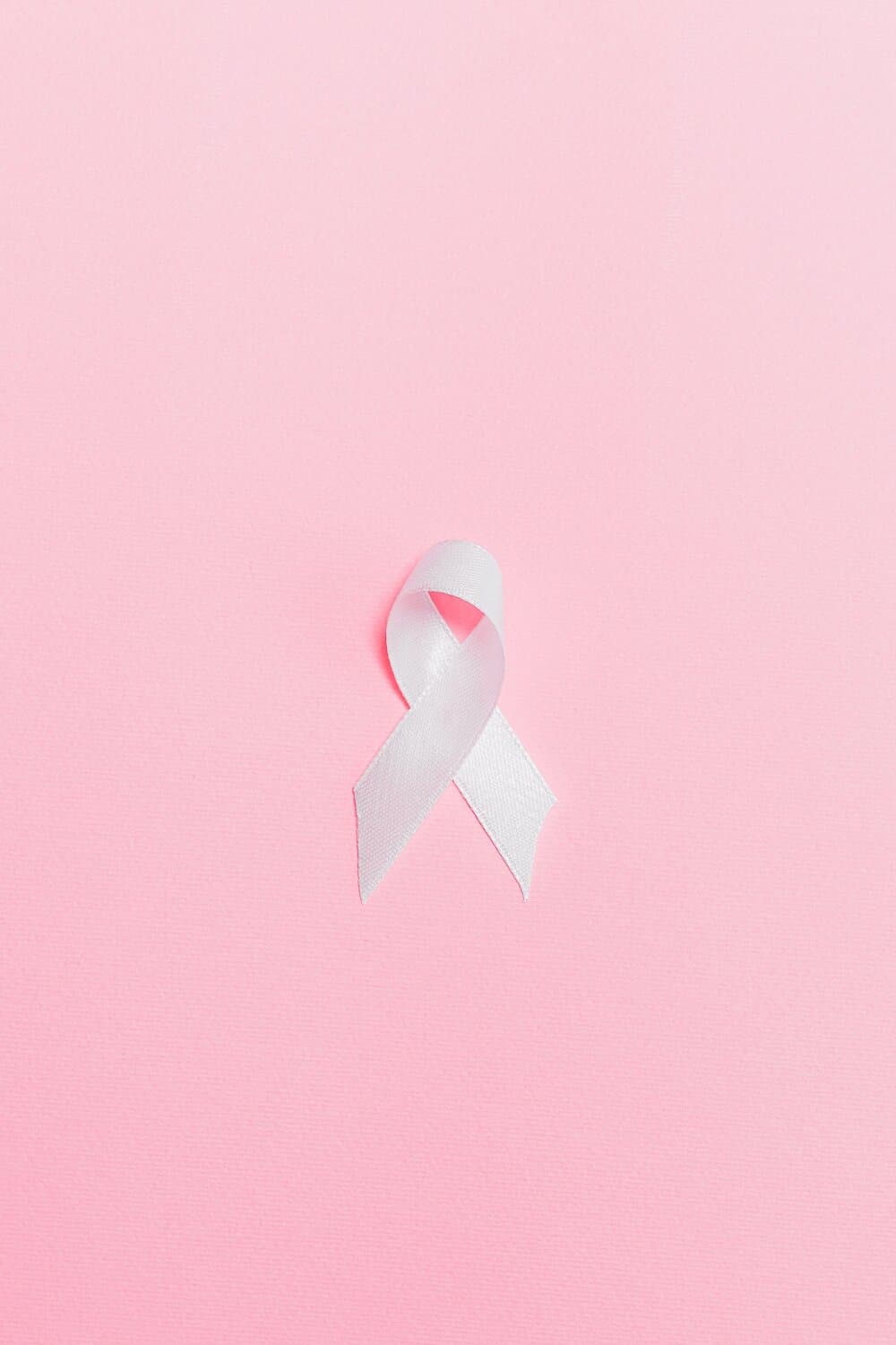 White ribbon on a pink background, symbolizing awareness and support. - Home Instead