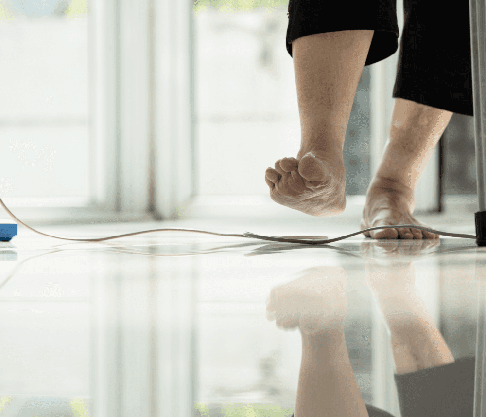 Person standing on tiptoes on a tiled floor, with a reflection visible. Only legs and feet are shown. - Home Instead