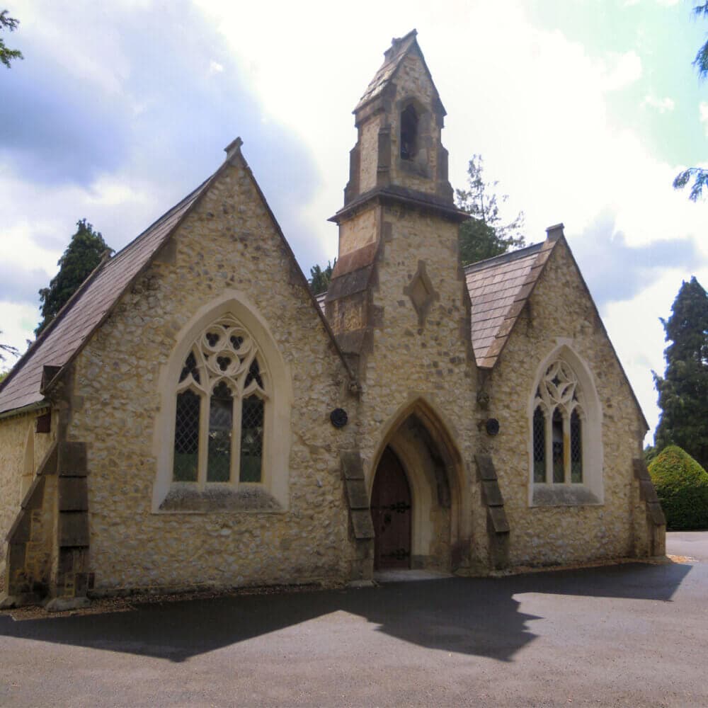 Small stone chapel with a central bell tower and pointed arch windows on a sunny day. - Home Instead
