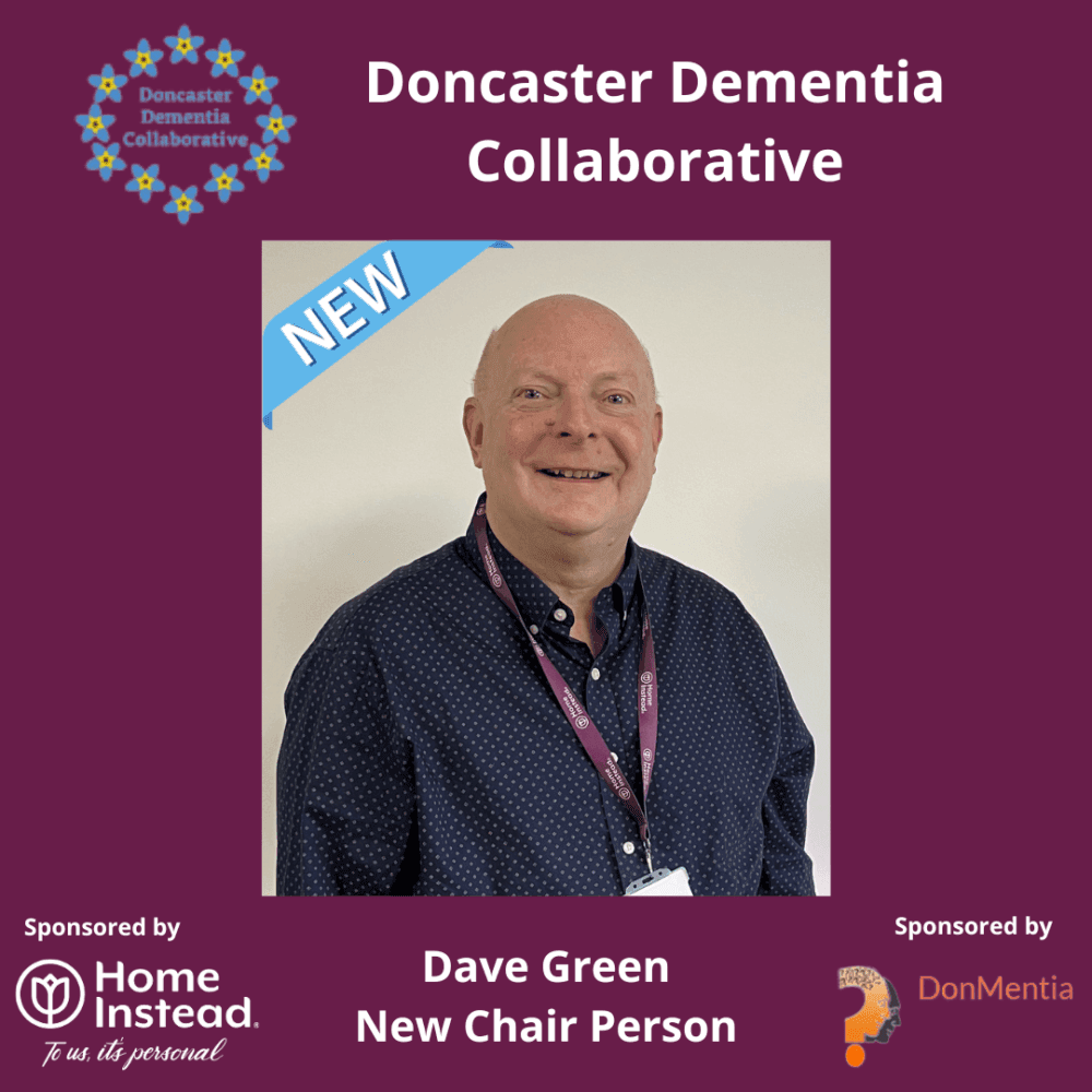 A smiling man in a blue shirt is introduced as the new chairperson for Doncaster Dementia Collaborative. - Home Instead