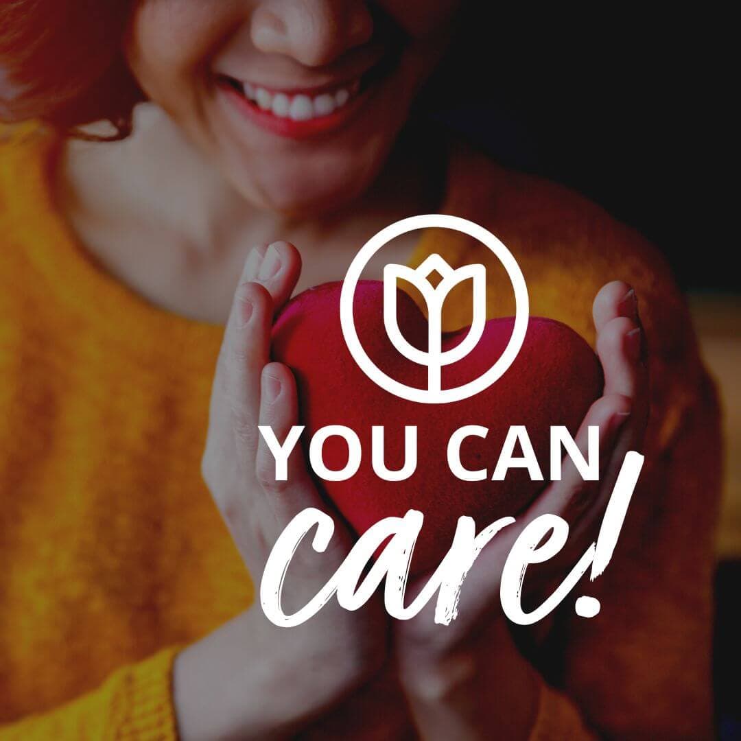Person holding a red heart, smiling. Text overlay reads "You Can Care!" with a flower logo above. - Home Instead