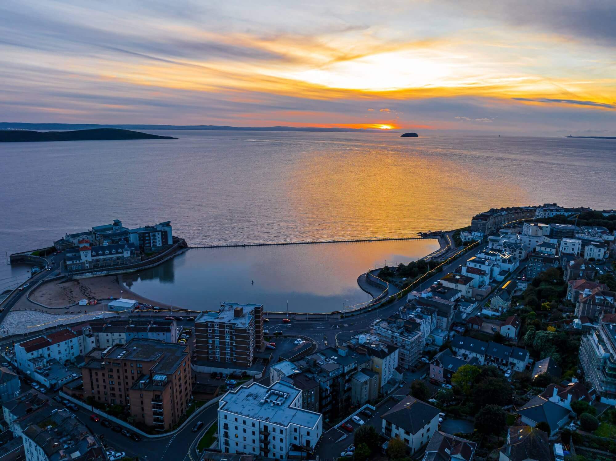 Aerial view of Weston-super-Mare at sunset, showing the beach, buildings, and a pier extending into the sea. - Home Instead