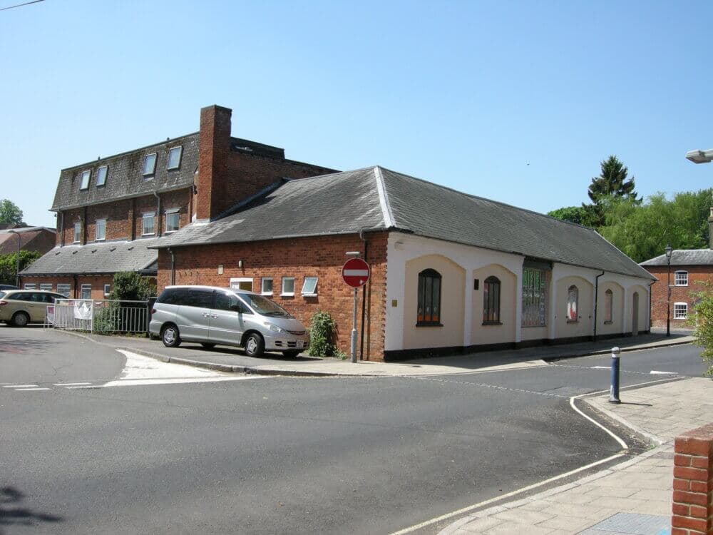 Street corner with a brick building, minivan parked, and no entry sign on a sunny day. - Home Instead