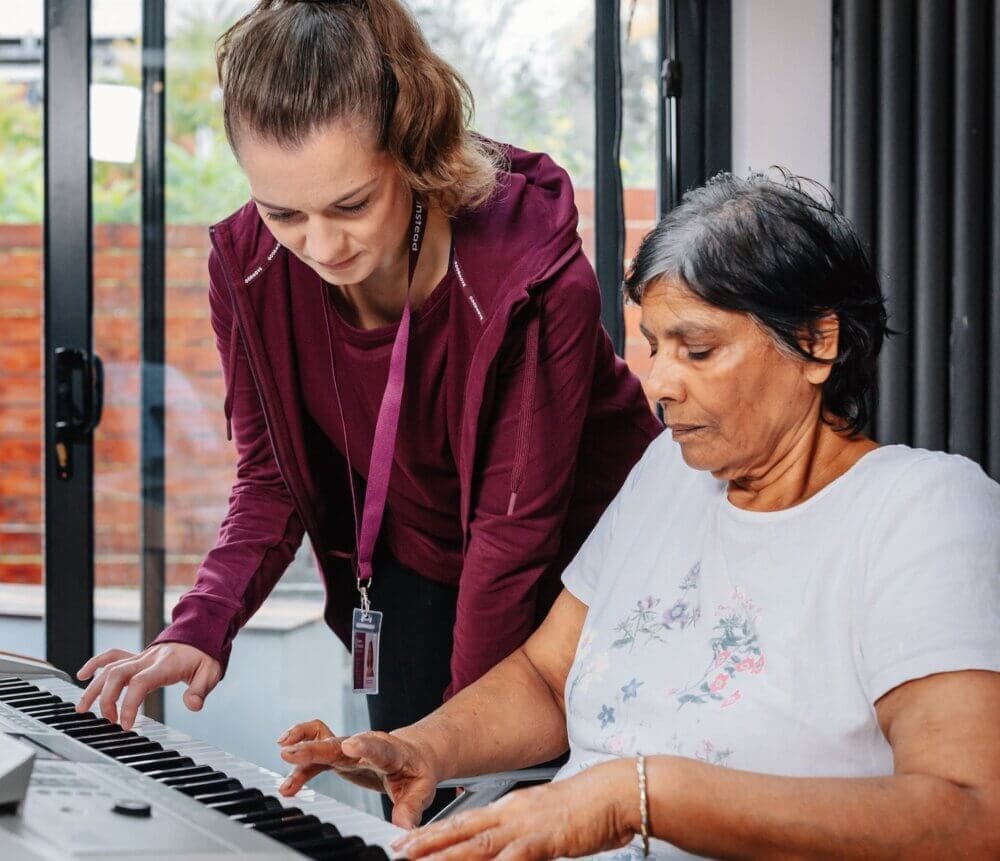 Care Professional playing the piano with client. - Home Instead