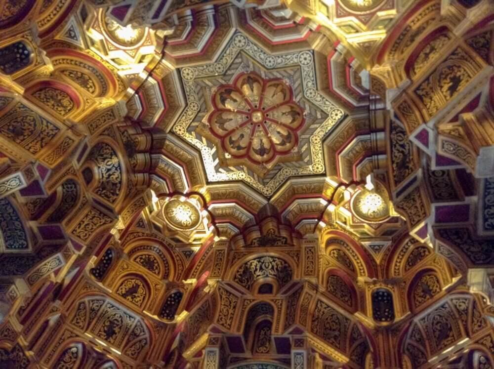 Elaborate, colorful, and intricate geometric patterns cover the ceiling of an ornate architectural structure. - Home Instead