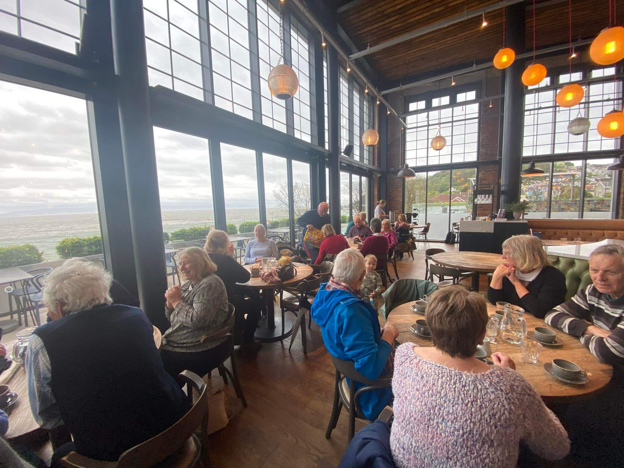 Group of seniors having coffee in local restaurant after social walk