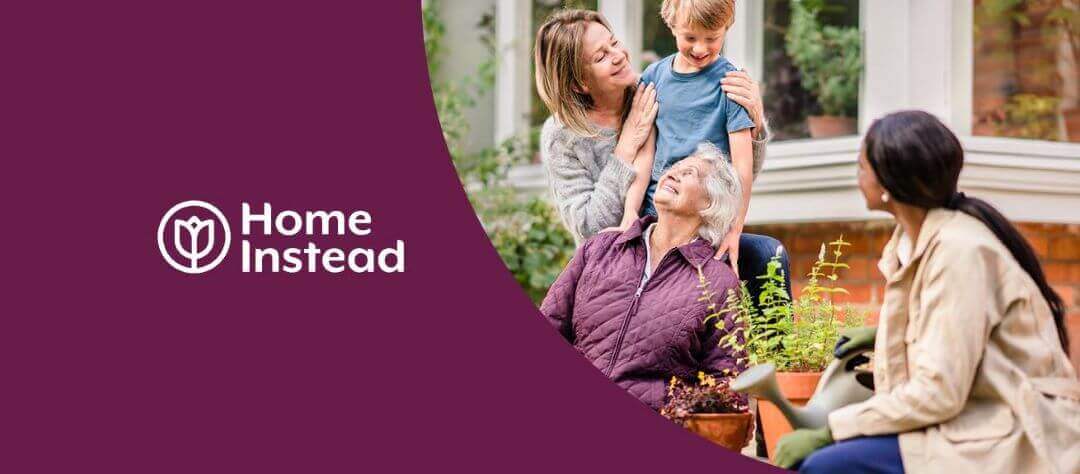 Four people, including an older woman, interacting happily outdoors with a logo and text "Home Instead" on a purple background. - Home Instead