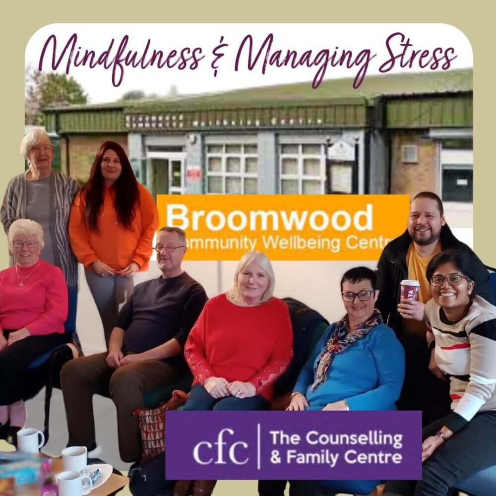 A group of people smiling and posing at the Broomwood Community Wellbeing Centre, with "Mindfulness & Managing Stress" text. - Home Instead