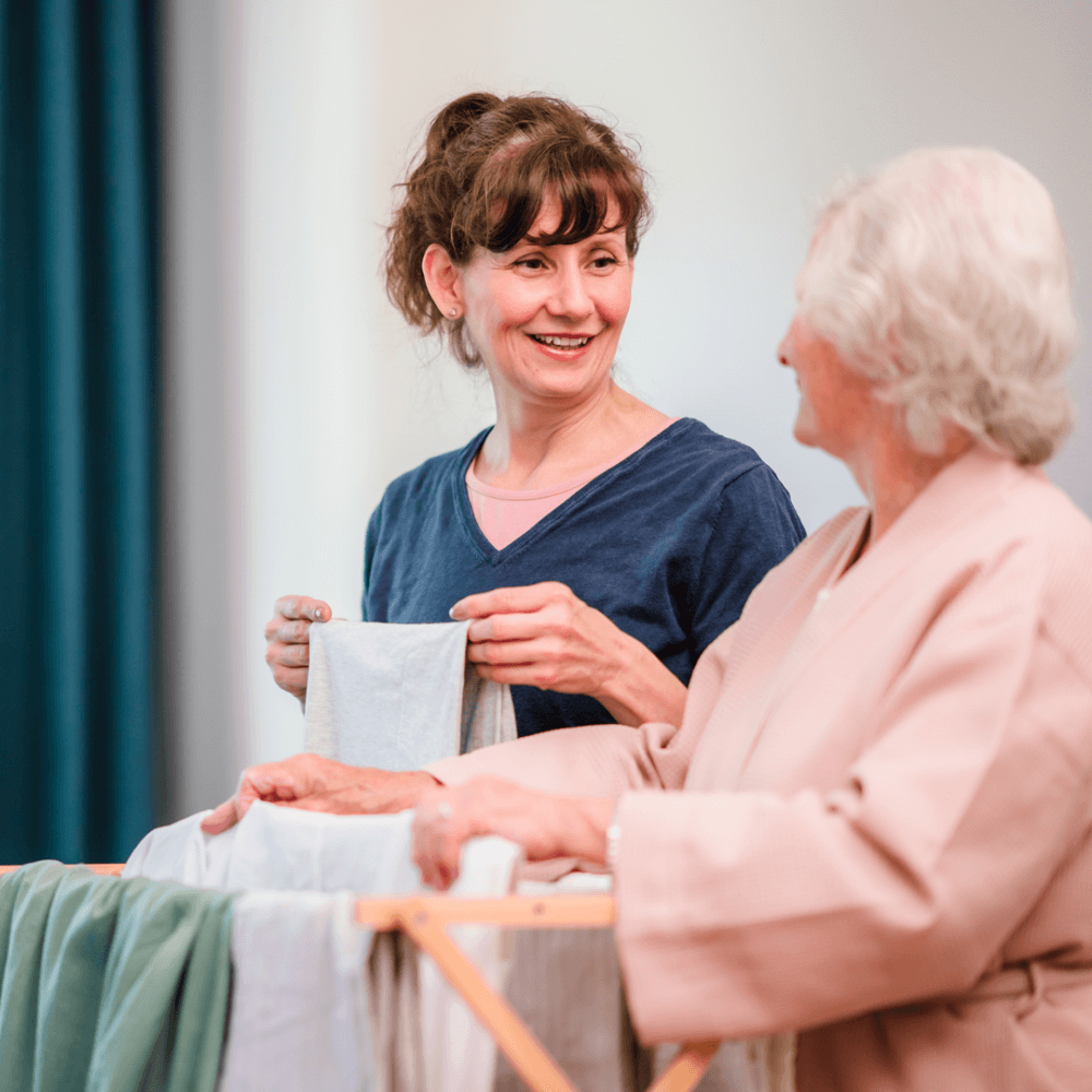 care professional hanging washing out with her client