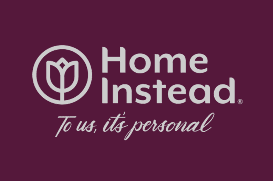 Home Instead logo with text 'To us, it's personal' in white on a maroon background. - Home Instead