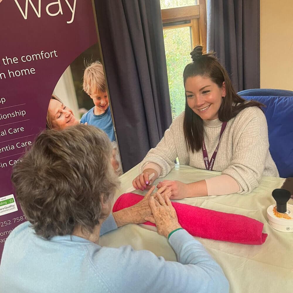 A senior lady enjoying in-home nail care and hand massage service from Home Instead team.