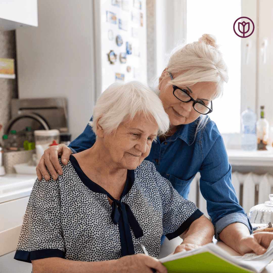 Daughter Helping mother who has dementia with paperwork. - Home Instead