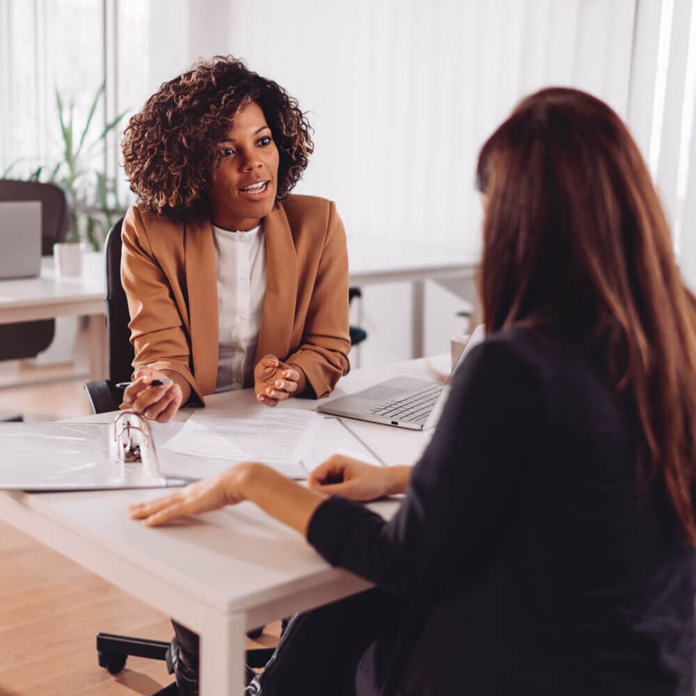 Care support worker talking with a female client at the office