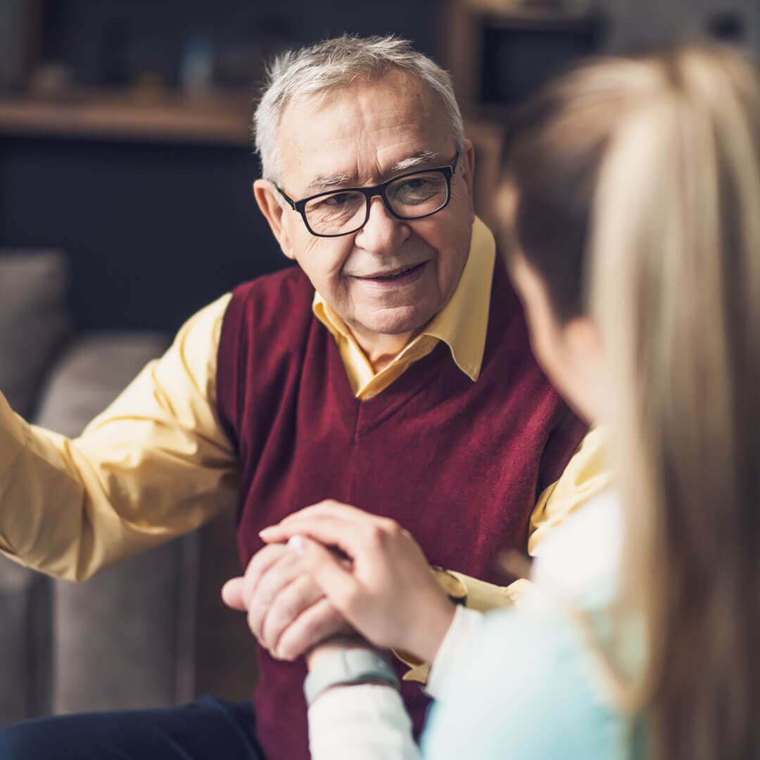 senior male client being supported by care professional