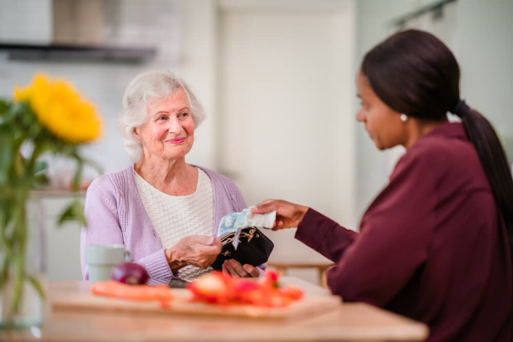Care Professional handing money to client - Home Instead