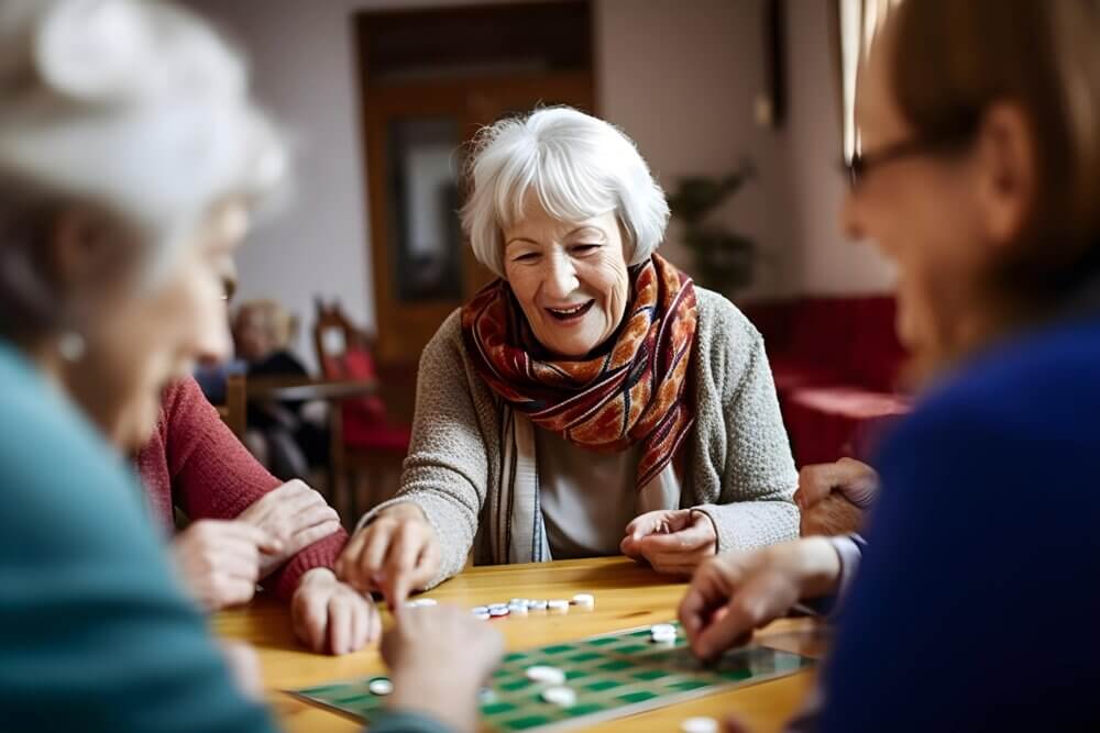Elderly woman smiling and playing a board game with friends. - Home Instead