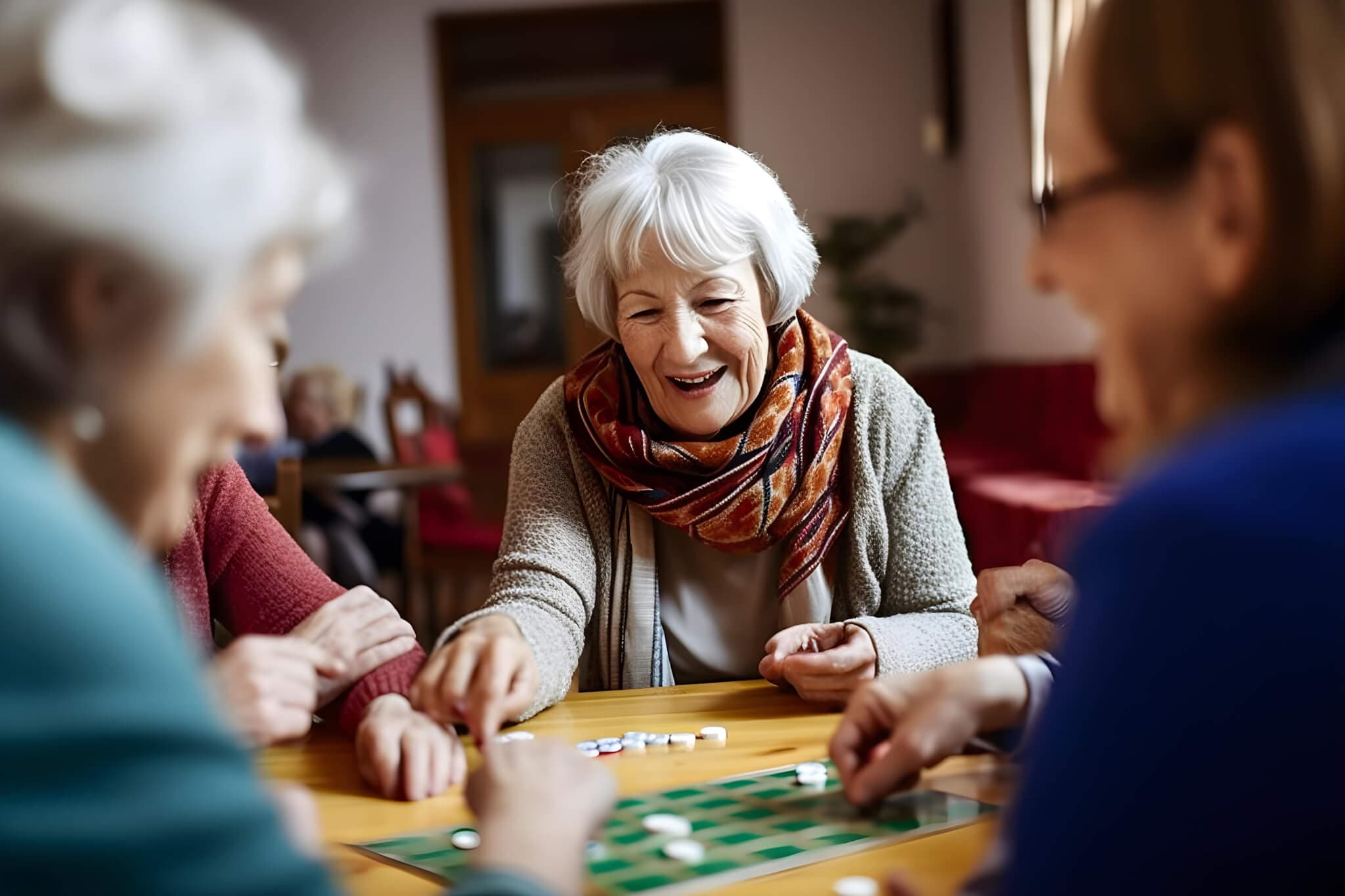 Elderly woman smiling and playing a board game with friends. - Home Instead