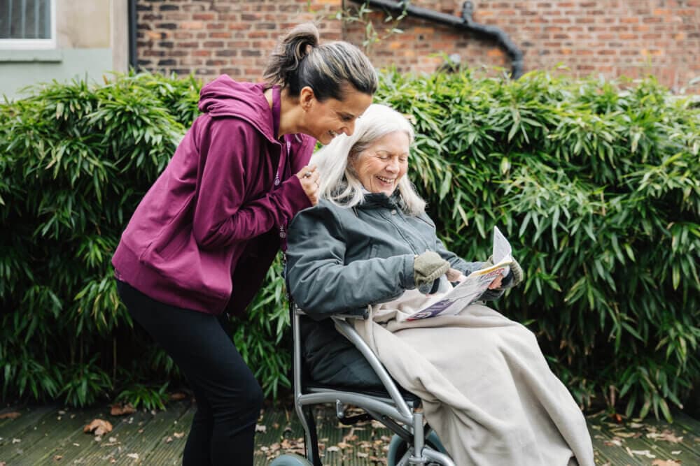 Care pro and client happily completing puzzles