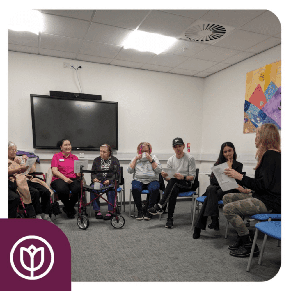 A group of people sit in a circle in a classroom, participating in a discussion or activity. - Home Instead