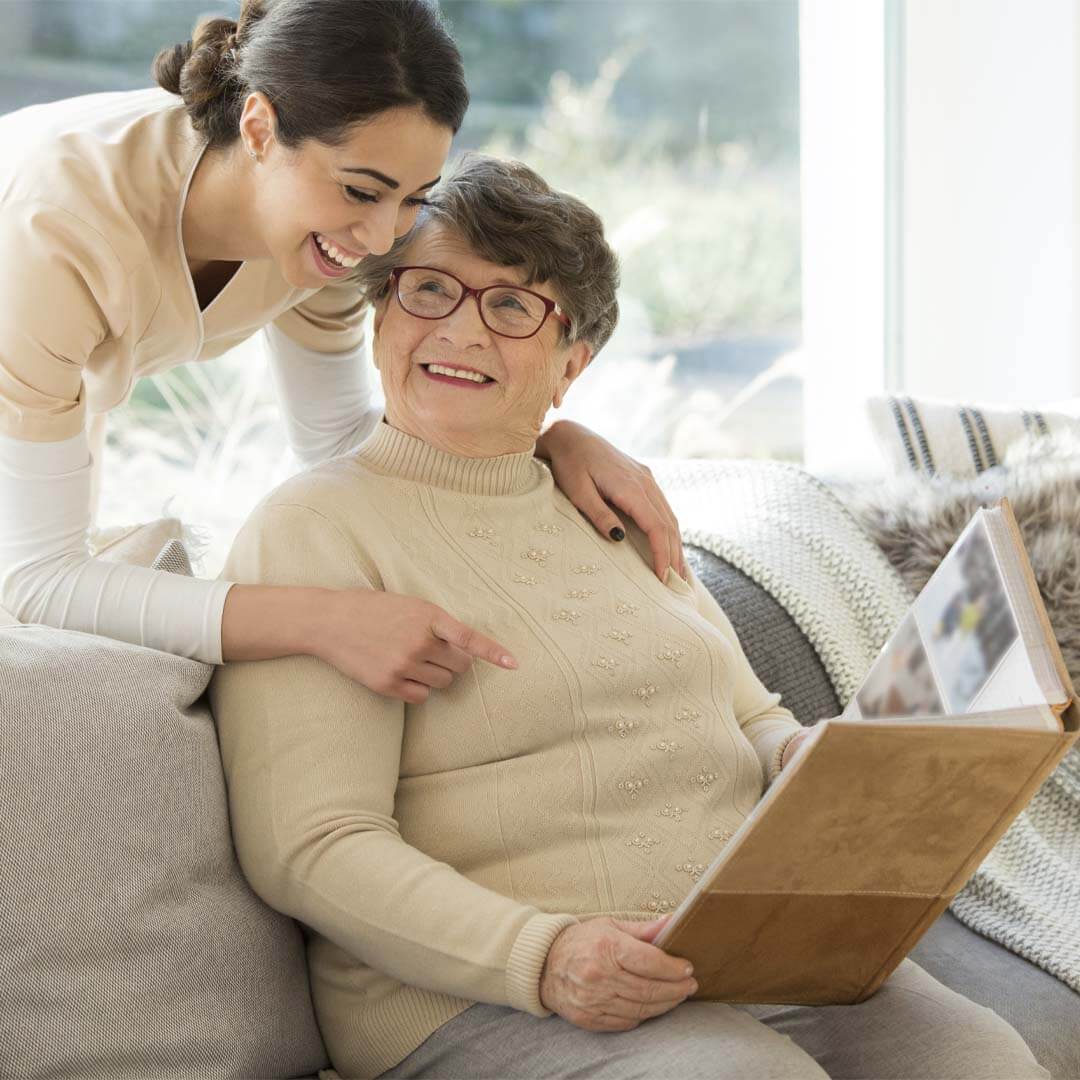 daughter and older mum looking through a photo album together