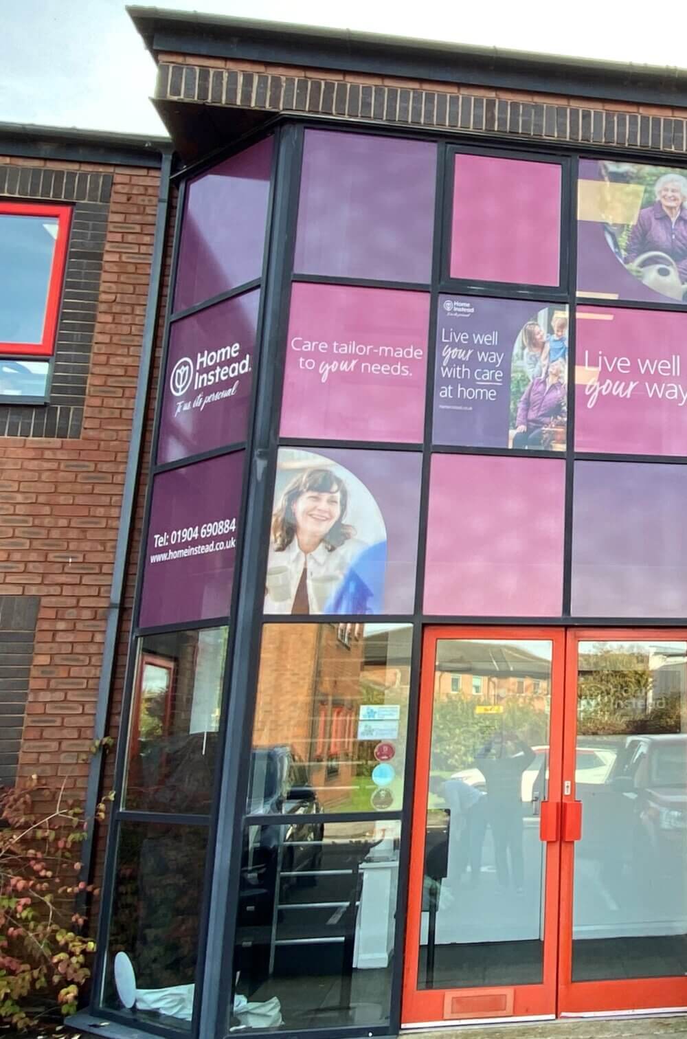 A building with purple and red signage for 'Home Instead', featuring images and text about tailored care services.
. - Home Instead