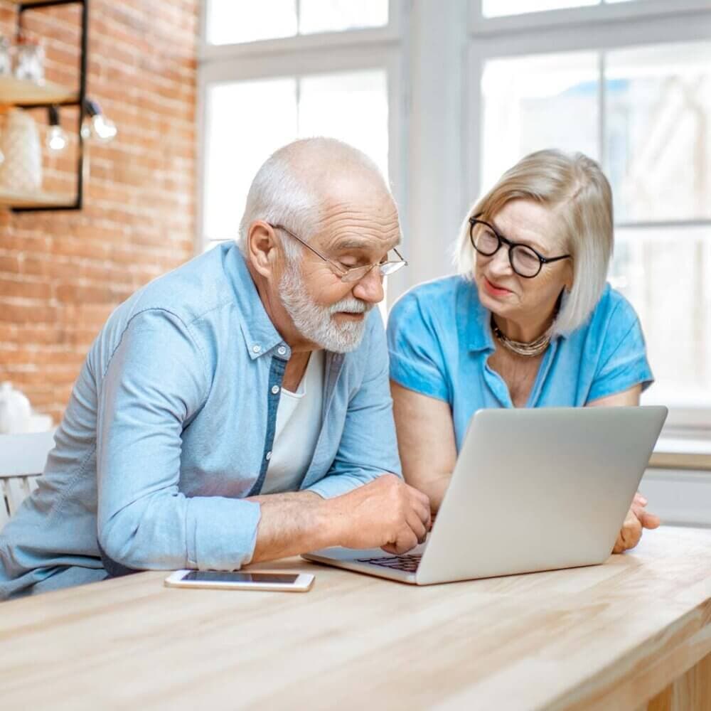 senior couple reviewing resources on a laptop