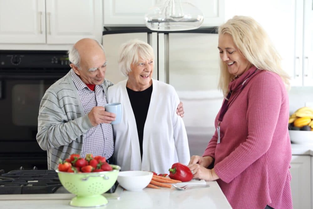 Home Instead live-in carer preparing meal for Jim and Betty