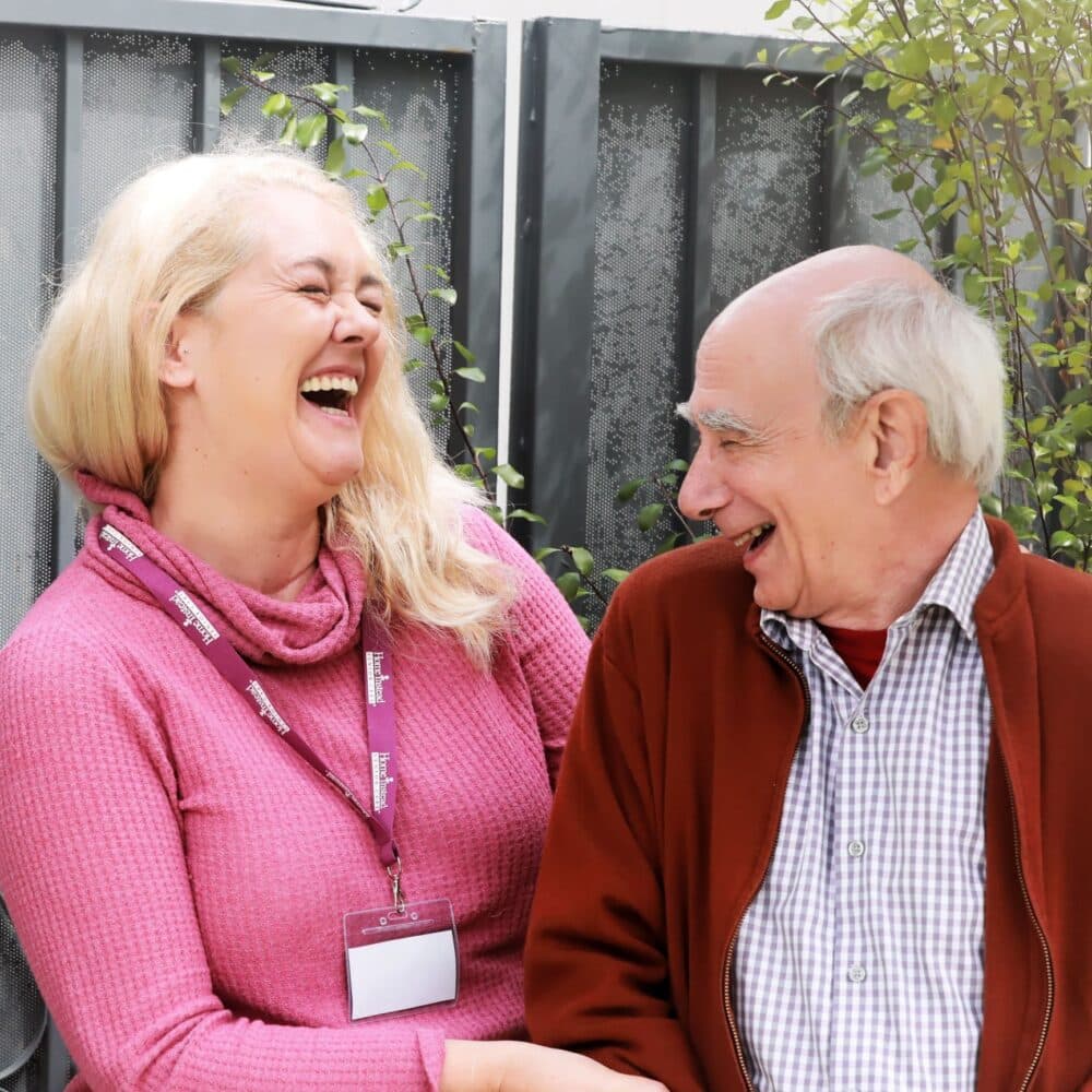 Elderly Home Instead male client laughing with his female Home Instead carer
