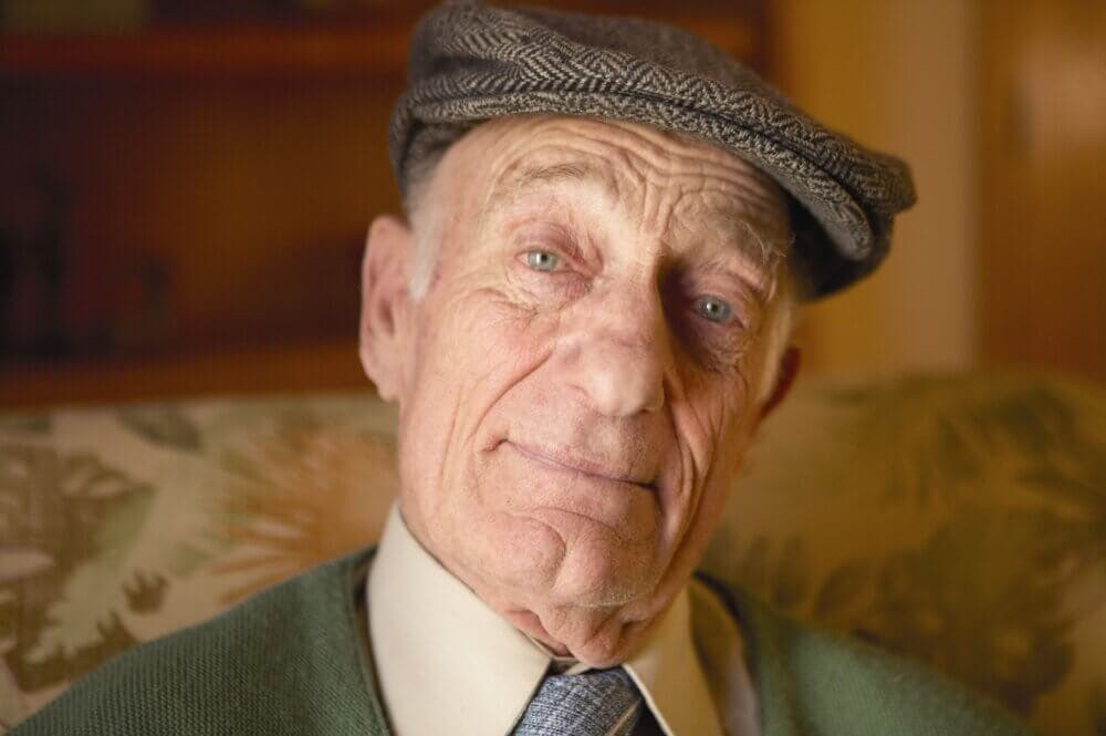 Home Instead client wearing a flat cap, with a gentle expression.