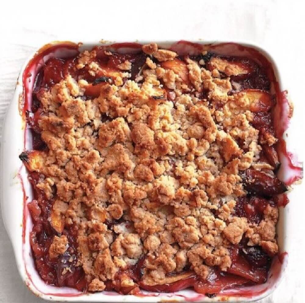 A baked fruit crumble with a golden brown, crumbly topping in a white square dish. - Home Instead