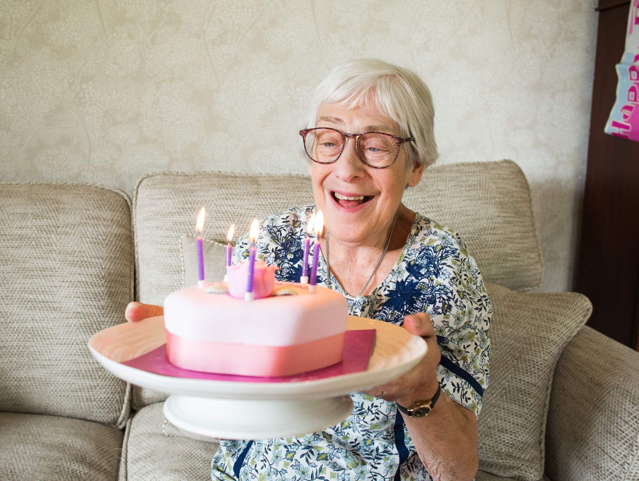 Home Instead client celebrating her birthday with a cake with candles on top
